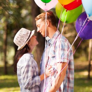 Guy holding ballons on a date with a girl who likes his shyness