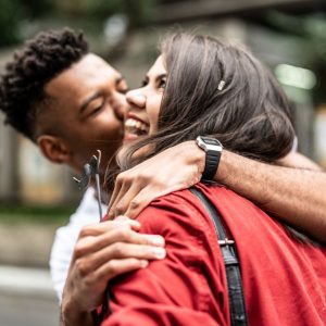 Girl smiling while guy kisses her on the cheek